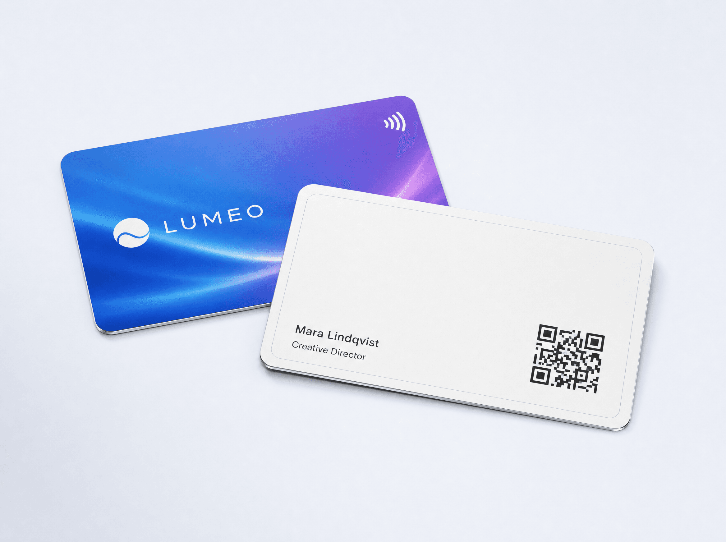 Two white Tapni metal cards: one printed edge to edge in color, one showing the QR code on the back